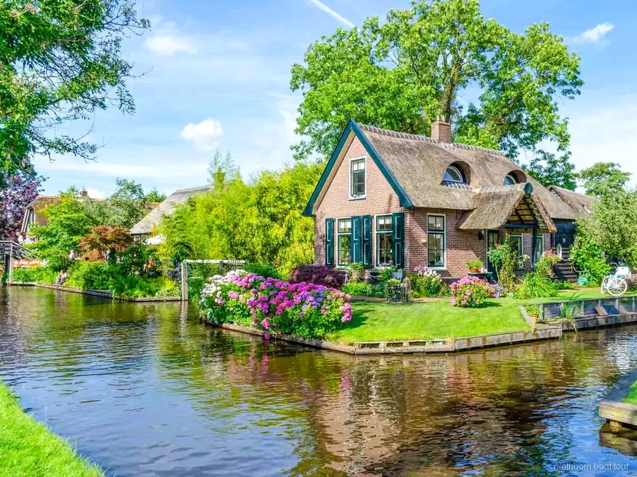 Stel stuurt hun eigen huurboot door een gracht in Giethoorn