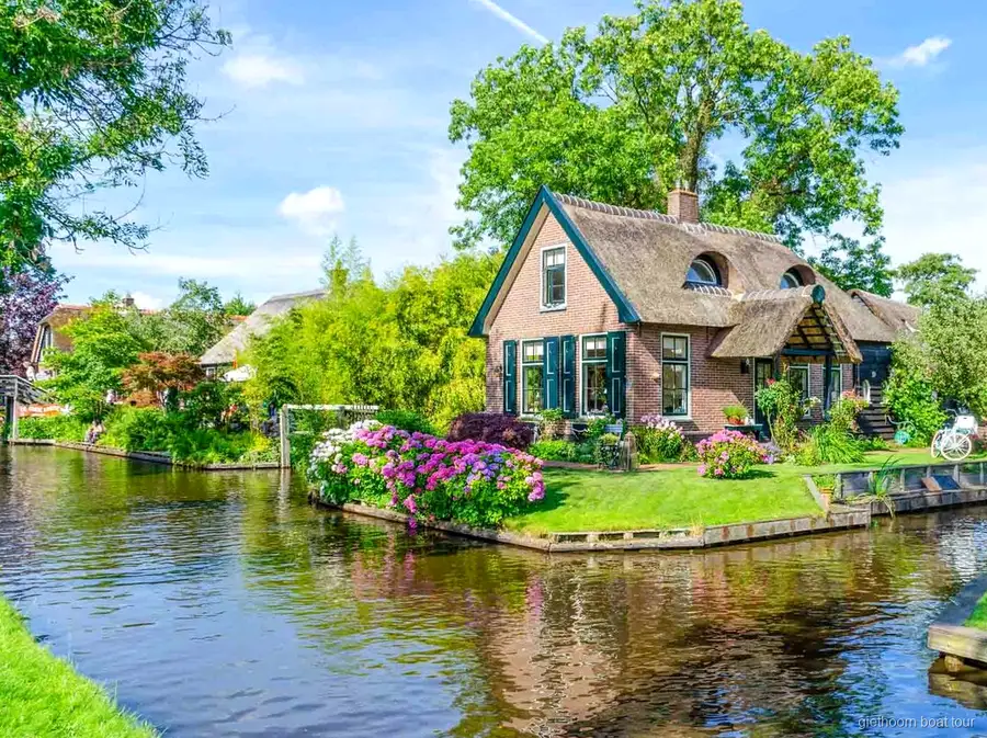 Couple pilotant son propre bateau de location sur un canal de Giethoorn