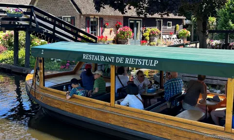 Croisière sur les canaux de Giethoorn passant devant des fermes aux toits de chaume près du centre du village