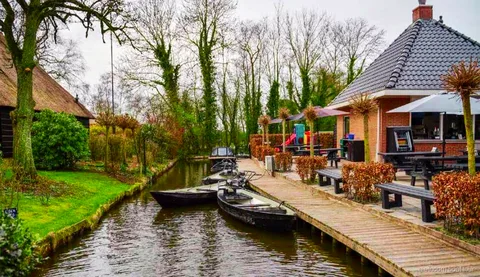 Hölzerne Bogenbrücke über eine Gracht im Dorf Giethoorn