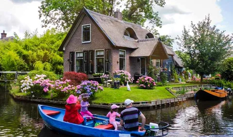 Thatched-roof farmhouses along a Giethoorn canal seen on the day trip