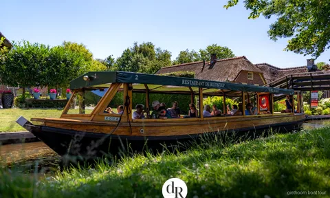 Overdekte rondvaartboot op een gracht in Giethoorn op weg naar Nationaal Park Weerribben-Wieden
